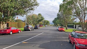 Eine Wohnstraße mit parkenden Autos und Häusern.