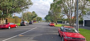 A residential street lined with parked cars and houses. - Coastal Retreat Herne Bay Near Beach and Cafes (Auckland)