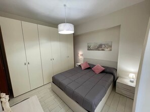 A bedroom with a bed, bedside tables, a wardrobe, and a hanging light fixture. - To complete (Agropoli)