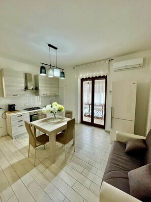 A modern kitchen with a dining table, chairs, and a sofa. - To complete (Agropoli)