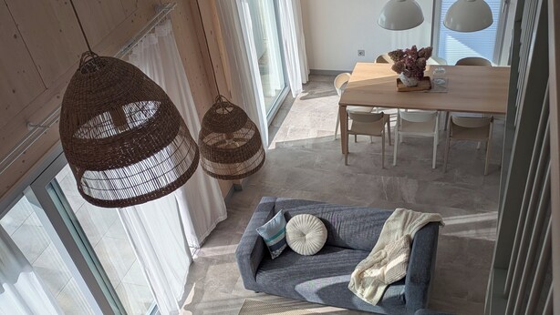 A modern living room with a sofa, two round coffee tables, and hanging wicker lamps. - Scandinavian Villa with sauna and hot tube and big garden. (Kołczewo)