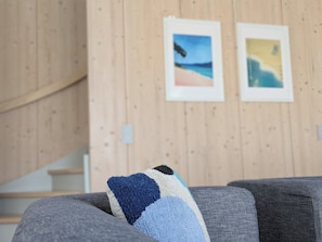 Une pièce avec un mur en bois, un escalier et deux tableaux encadrés.