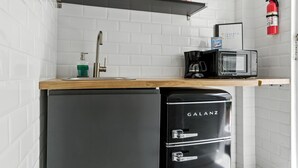 A compact kitchen with a Galanz refrigerator, a microwave, a coffee maker, and a shelf with a fire extinguisher. - 1BR 1BA Sleeps 3 Wi-Fi  Walk to Beach (San Juan)
