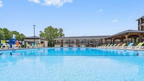 Une piscine avec des chaises longues et un bâtiment en arrière-plan.