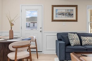 A dining area with a table, chairs, and a vase of dried plants. - Modern 3BR | Heart of Ventnor | Beach Gear Incl (Ventnor City)