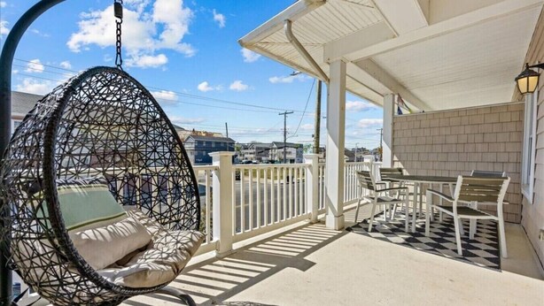 Ein Balkon mit einer Hängematte, einem Tisch mit Stühlen und Blick auf die Stadtlandschaft.