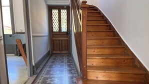 Un escalier en bois menant à une porte dotée d’une fenêtre.