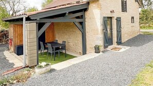 A single-story house with a sloped roof, a covered patio, and a gravel driveway. - The Pechplazen grangette (Rudelle)