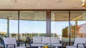 Una habitación moderna con sofá, sillones, una mesa de centro y una cama.