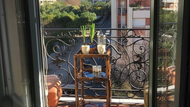 A balcony with a table, potted plants, and a hanging light fixture. - LOVELY LITTLE NEST FOR UP TO 5 PEOPLE, PETS WELCOME (Nice)