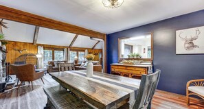 A dining area with a wooden table, chairs, and a large mirror on the wall. - Pine Loch, cozy cabin sleeps 9 with 3 bedrooms, 2 baths. Gas fire pit on deck. (Pocono Lake)