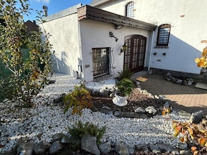 A building with a white exterior, a gated entrance, and a small garden area with white pebbles and rocks. - Apartchrisbea Self-catering accommodation (Namur)
