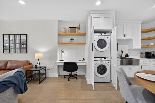 A compact living space with a desk, chair, and a washing machine. - Modern Brownsville Duplex Near SPI & Downtown (Brownsville)