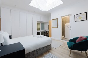 Une chambre à coucher moderne comprenant un lit, un bureau, une chaise et un dressing.
