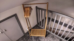 Een hoek van een kamer met een houten stoel, een deur en een trapleuning.