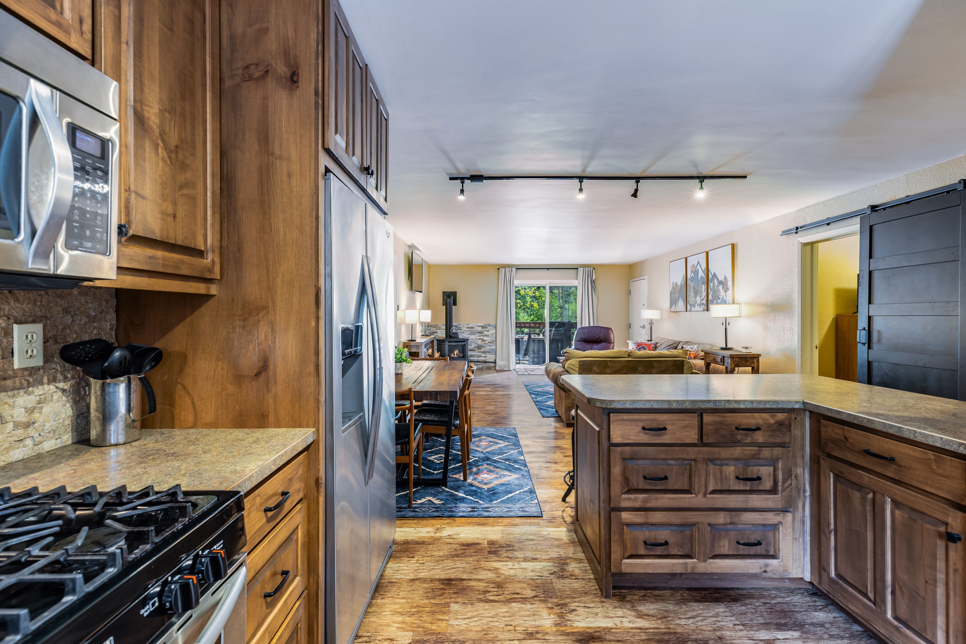 A modern kitchen with wooden cabinets, stainless steel appliances, and a central island.