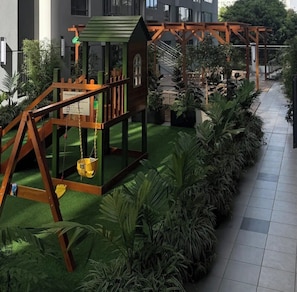 A children's play area with swings and a small house structure. - A calm, stylish escape 
Perfect for productive workdays or relaxing getaways. (Nairobi)