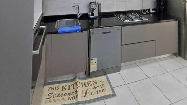 A modern kitchen with wooden cabinets, a stainless steel sink, and a built-in dishwasher. - RESIDANCE F5 FRANGE MARITIME An AKID LOTFI (Bir El Djir)
