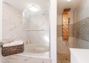 Ein modernes Badezimmer mit einer Duschkabine, einer Badewanne und einem Waschtisch mit Spiegel.