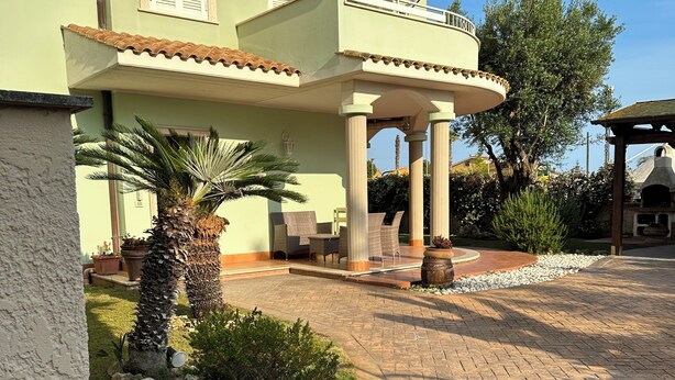 A two-story house with a covered patio area, outdoor seating, and a barbecue grill. - In quiet and relaxing setting 1.5km from the sea, suitable for families and friends, (Anzio)