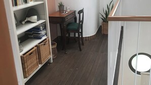 A room with a wooden floor, a white bookshelf, a small table with a chair, and a potted plant. - In quiet and relaxing setting 1.5km from the sea, suitable for families and friends, (Anzio)