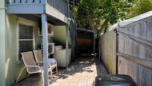 A covered outdoor area with a grill, chairs, and a suitcase. - Downtown Sarasota Rental, 2 Units,4 Bedrooms,3 Baths, Sleeps 10, Lido Beach 6min (Sarasota)