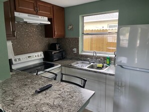 A kitchen with a stove, microwave, sink, and refrigerator. - Downtown Sarasota Rental, 2 Units,4 Bedrooms,3 Baths, Sleeps 10, Lido Beach 6min (Sarasota)