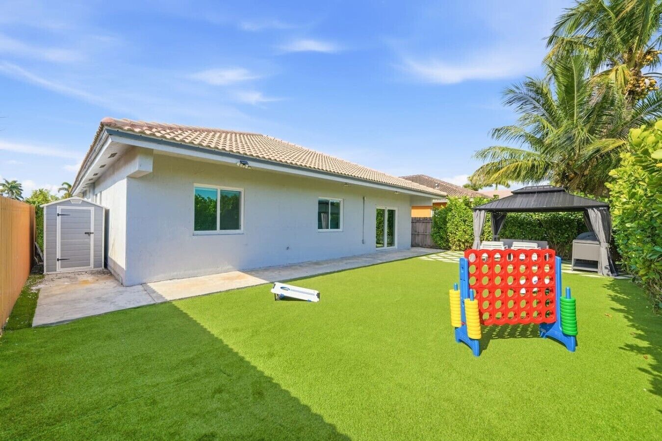 A house with a white exterior, a tiled roof, and a well-maintained lawn.