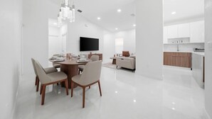 Ein modernes Interieur mit Essbereich, Flachbildfernseher und Küche.