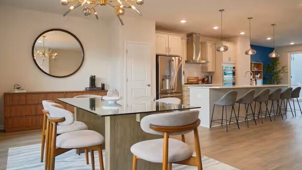 A modern kitchen with a central island, bar stools, and pendant lighting. - Brand-New- Rooftop Luxe 4BR/5BA, 15 Min to DC+ MGM (Upper Marlboro)