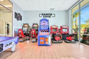 A gaming zone with arcade machines, a pool table, and a sign reading 'GAMING ZONE'. - Dream Home 7BR – Pool, Hot Tub, Game Room & Theater - Near Disney! (Davenport)