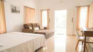 A hotel room with a bed, a sofa, a desk, and a chair. - River Suite with River View (Kochi)