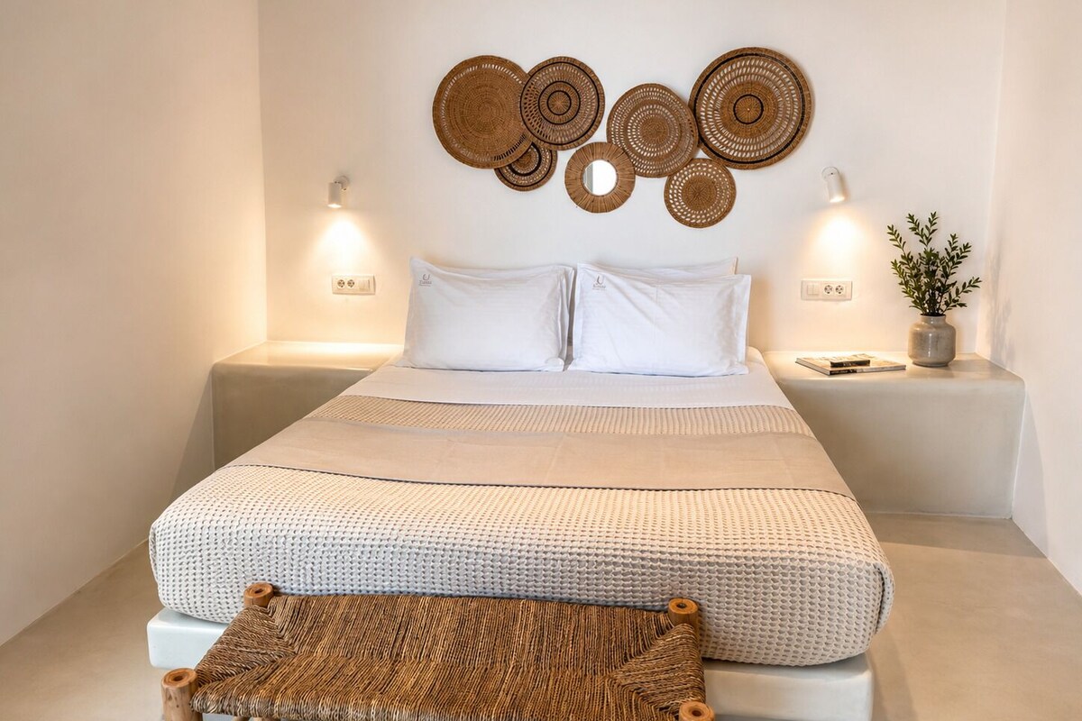 A neatly arranged bed with white linens, a woven headboard, and two bedside lamps.