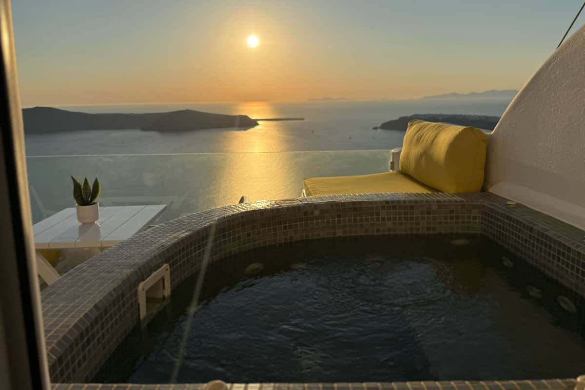 A hot tub with a view of the sea at sunset.