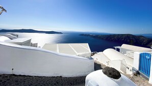 A coastal view with white buildings, a clear sky, and the sea. - Esmi Suites Santorini (Imerovigli)