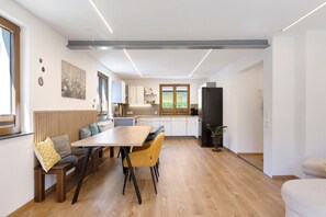 Eine moderne Küche mit einer Holbank und einem Tisch, einem Kühlschrank und einem Fenster mit Aussicht.