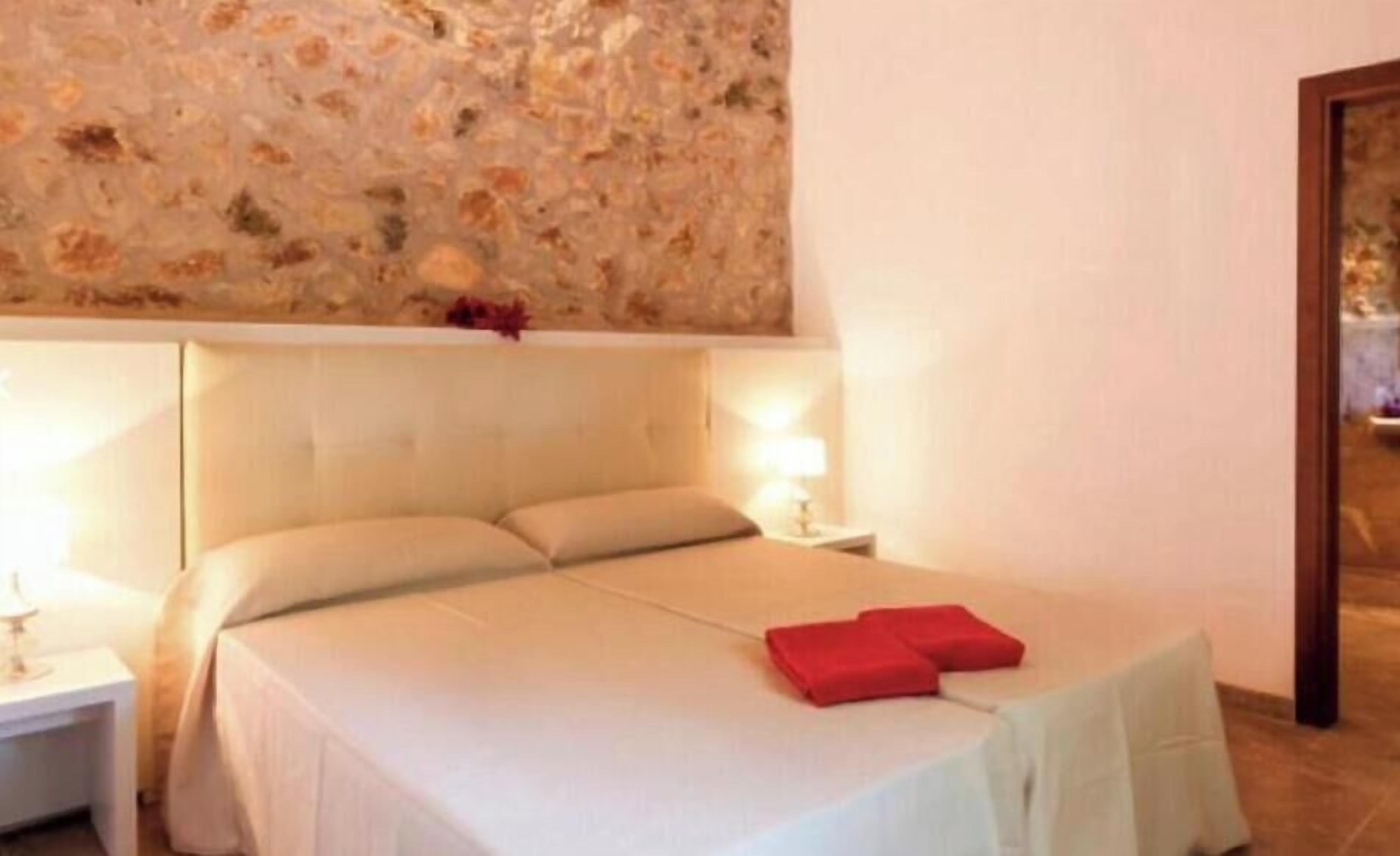 Una camera da letto con un letto, due comodini e una parete con motivo decorativo.