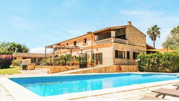 A two-story house with a swimming pool, surrounded by greenery and palm trees. - Ayurvila Wellness Retreat: 1-bedroom apartment (Manacor)