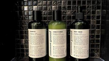 Three bottles of hair care products against a tiled wall.