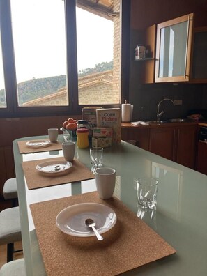 A kitchen with a long counter, a sink, and a window with a view of the hills.