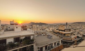 Ein Stadtbild bei Sonnenuntergang mit mehreren Gebäuden und wolkenlosem Himmel.