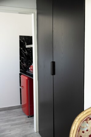 Ein Zimmer mit einem dunklen Holzschrank, einem roten Gerät und einer Marmorarbeitsplatte.