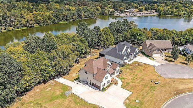 A residential area with houses, a driveway, and a lake. - Lake Days & Nashville Nights — Private Dock, Game Room & Fire Pit - Room for 12 (Gallatin)