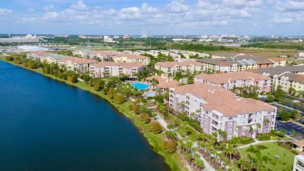 Un quartier résidentiel bordé de bâtiments d’appartements, situé au bord de l’eau, avec une piscine et un ciel dégagé.