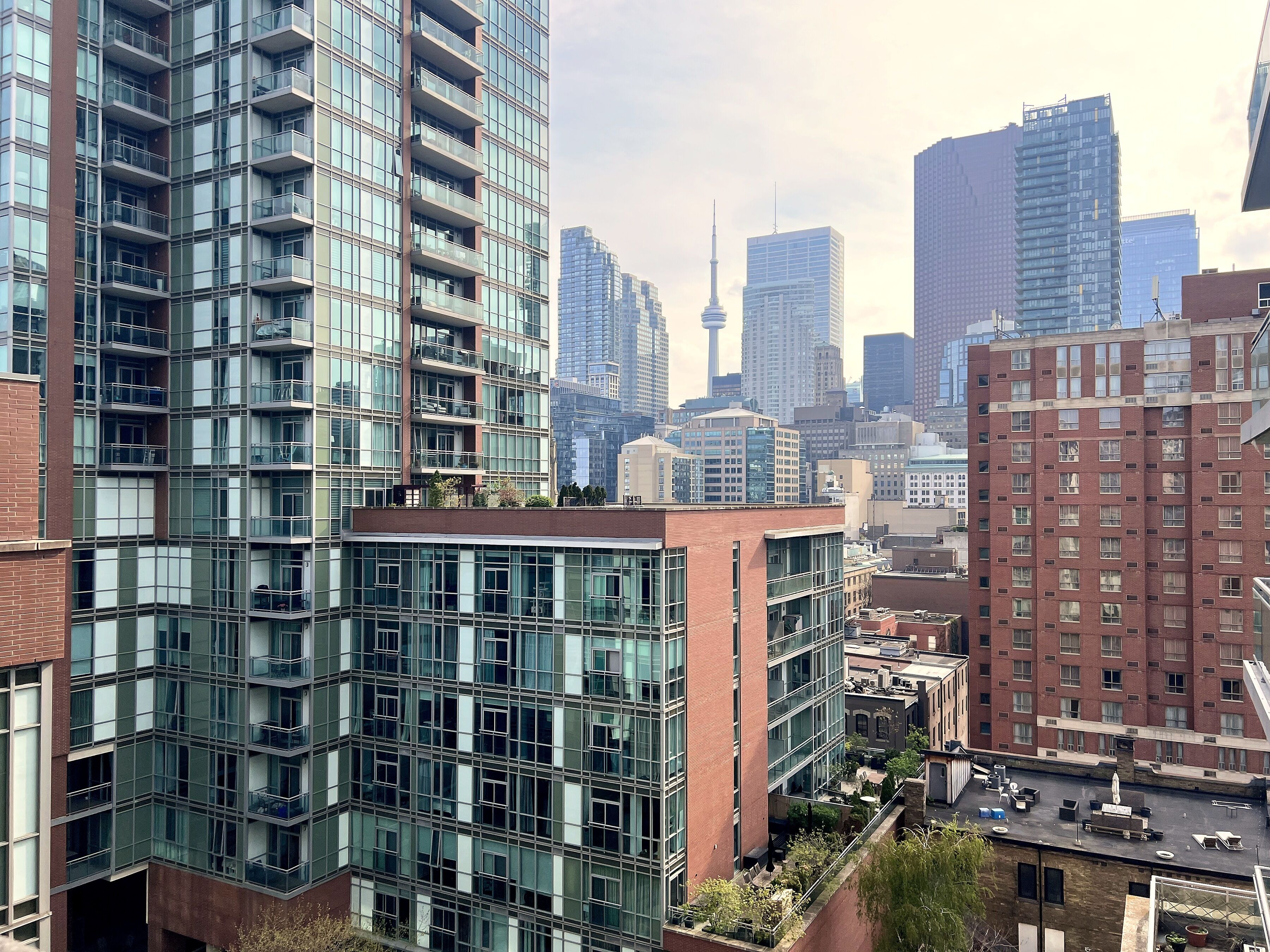 A high-rise building with multiple balconies and a rooftop terrace.