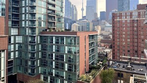 A high-rise building with multiple balconies and a rooftop terrace. - 2-bed, 2-bath spacious condo one block from St Lawrence market (Toronto)