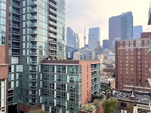 A high-rise building with multiple balconies and a rooftop terrace.