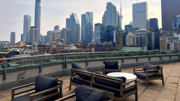 A rooftop terrace with outdoor seating and a city skyline in the background. - 2-bed, 2-bath spacious condo one block from St Lawrence market (Toronto)