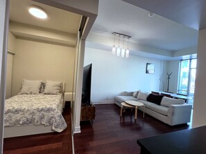 A modern living room with a sofa, a coffee table, a flat-screen TV, and a wooden cabinet.