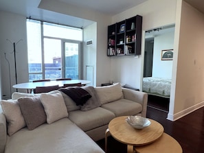 A modern living room with a sofa, a round coffee table, and a bookshelf.
